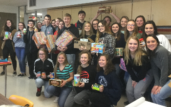New Richmond High School Student Council officers show off some of the 16,521 items collected in this year’s record-breaking canned food drive to benefit the New Richmond Food Pantry.