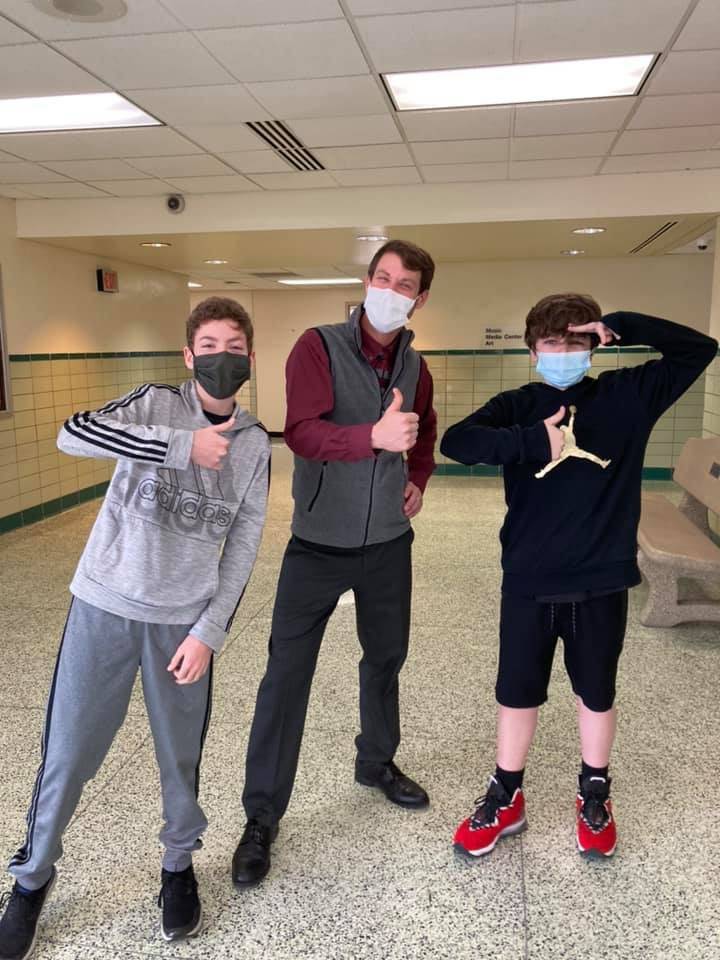 NRMS Principal poses with two students for a silly social photo as a reward to the students