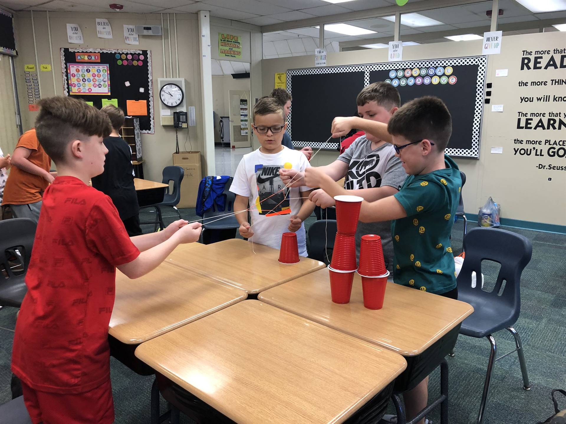 first day fifth graders doing a challenge with string and cups